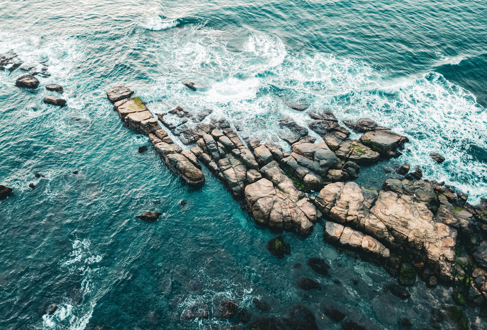 aerial view of water splashing on a rocky shore